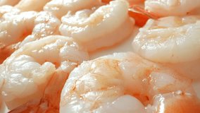 Frozen shrimp: caught, processed, frozen to preserve freshness, flavor. Popular worldwide for versatility, mild flavor, quick cooking. Freezing extends shelf life, ensures safety. Seafood background.
