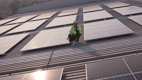Drone view of engineer worker installed solar panels on roof of house. Attractive male maintenance of a photovoltaic panel system installed on rooftop of a residential home within an urban landscape. - Powered by Shutterstock - Get 15% off with code: PIKWIZARD15