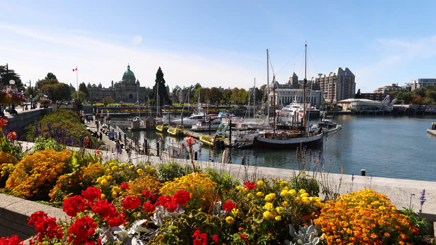 Victoria, British Columbia on beautiful summer day with flowers. Victoria inner Harbour and British Columbia Parliament Buildings, Vancouver Island, BC, Canada