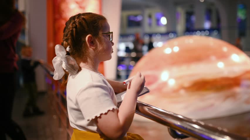 child studies an exhibit in a museum, a planets , meteorite. High quality 4k footage