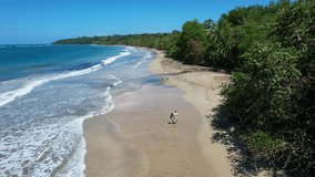 Beautiful drone video of a couple walking on a beach from Costa Rica