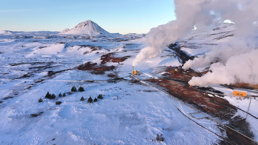 Snow-covered geothermal plant in Myvatn with steam rising against a clear sky Royalty-Free Stock Footage #3466832339
