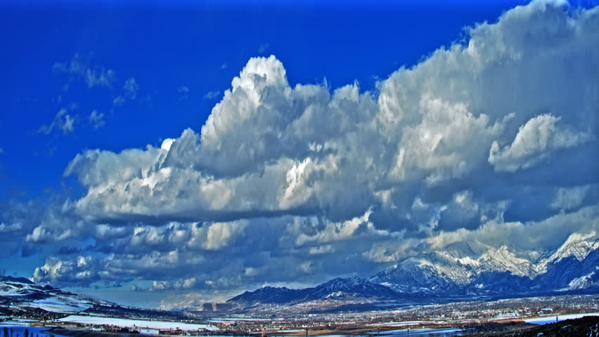 HD timelapse of big rolling clouds over a beautiful winter landscape.