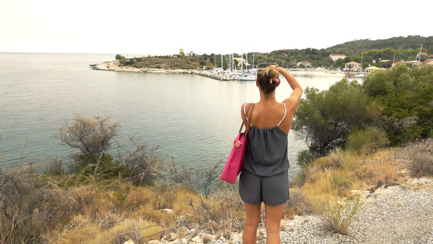 Woman taking photo of port with cellphone on island, super slow motion 240fps
