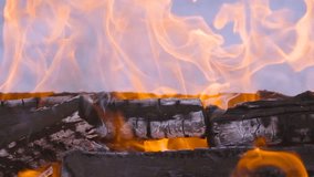 Slow-motion video with fire and flames.A bonfire,burning firewood with fire and smoke.Flames and burning sparks in close-up,fire patterns.The infernal glow in the brazier.A burning fireplace.Fuel wood