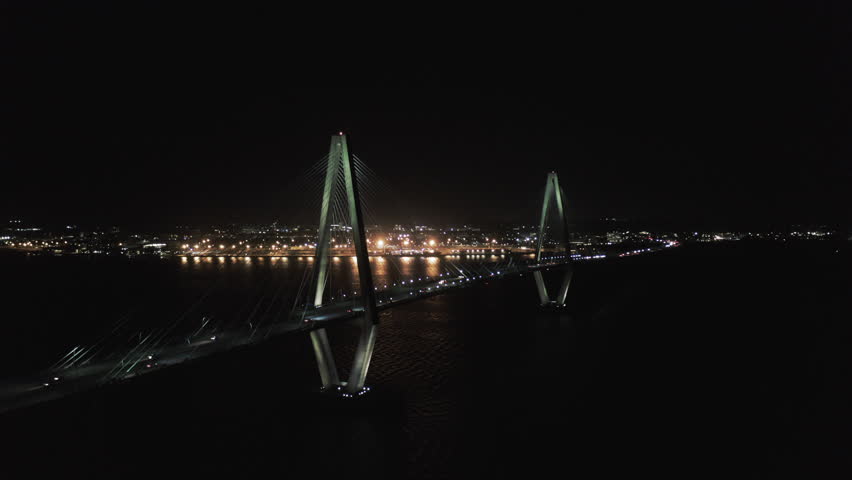 Aerial Panning Shot Of Illuminated Cable-Stayed Bridge In City, Drone Flying Over Cooper River At Night - Charleston, South Carolina