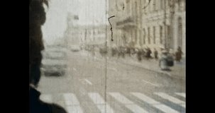 Urban traffic in Europe old city, view through bus front glass. 1980s Petersburg Russia. Cars drive. People on Nevsky Prospect street architecture. Vintage archives. Archival color film. Retro archive
