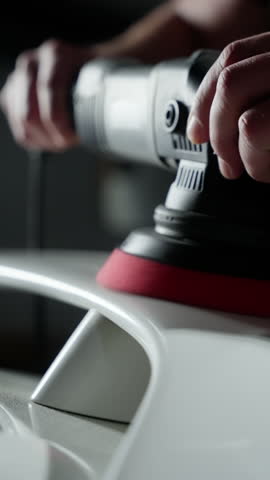 A person is polishing a car with a polisher