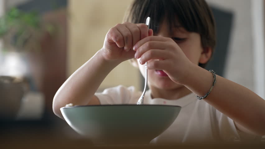 Spaghetti delight - Little boy attempting to spin fork while eating pasta food during mealtime. Child enjoying learn to use utensils Royalty-Free Stock Footage #3467129379