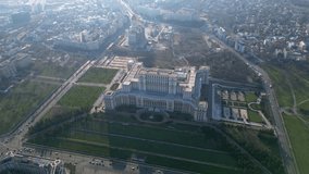 High angle drone footage of the Palace of the parliament in Bucharest Romania. Constitution Square seen from above on a sunny green day. Ceausescu's palace seen from above. Flyover shot