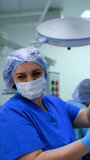 Positive smiling female nurse wearing blue uniform. Medic filling the large syringe with white medicine. Vertical video.