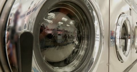 This is a shot of some Washing Machines Washing Clothes in a Laundromat.  