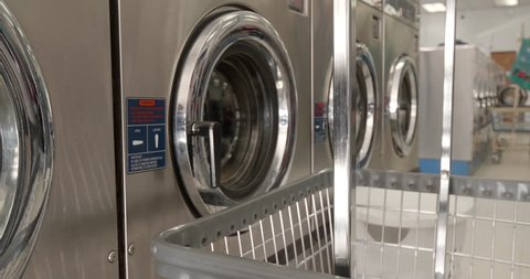 This is a shot of some washing mashines washing clothes at the laundromat.  