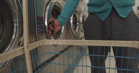 This is a shot of a man putting his clothes into the dryer at the laundromat. Shot on a GH5.