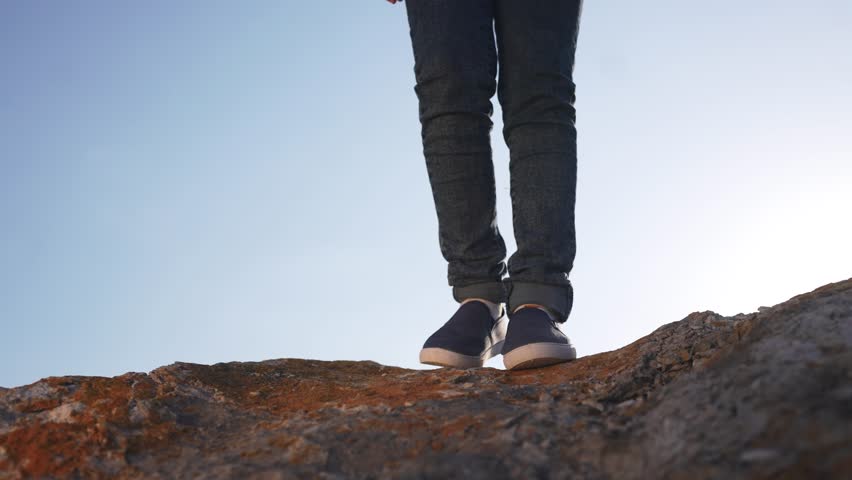 baby boy playing in mountains rocks park. close-up child feet walking on mountains rocks. happy family kid dream concept. a child in sneakers walks on mountains rocks park lifestyle