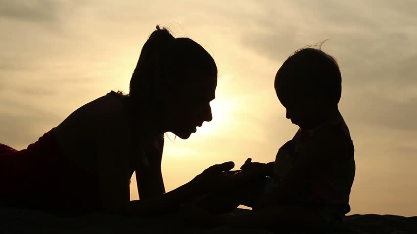 Outline of happy mother playing with her daughter while sunset