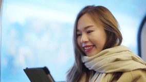 4K Digital nomad and Business travel. Asian Businesswoman remote working corporate business video conference on digital tablet during travel on train. Woman freelance working online outside office.