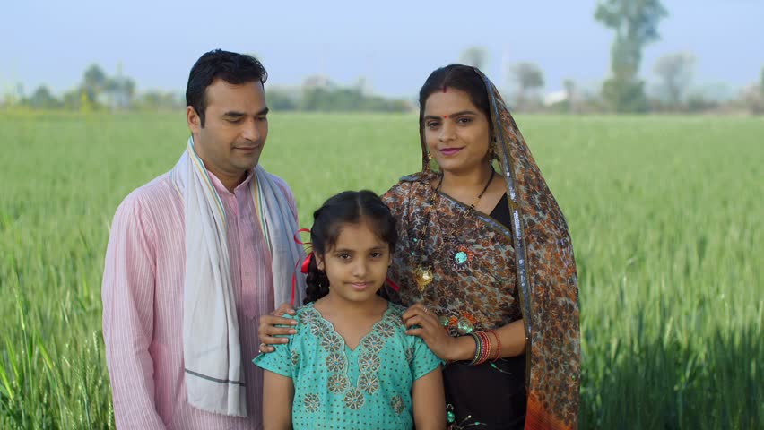 Young age farmer happily posing with his family - village couple, desi family, rural lifestyle, nuclear family, girl child. A village couple spending quality family time with their daughter - small... Royalty-Free Stock Footage #3467292421