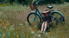 Lady In Hat Enjoying Weekend On Holiday Vacation Trip. Woman In Dress Relaxing. Woman Sitting On Flower Meadow And Reading Book Diary. Blonde Girl On Weekend. Tourist Girl Relaxing On Wildflower Field - Powered by Shutterstock - Get 15% off with code: PIKWIZARD15