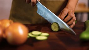 Chef cuts cucumber on a cutting board close-up slice of cucumber. Slicing cucumbers on a cutting board.