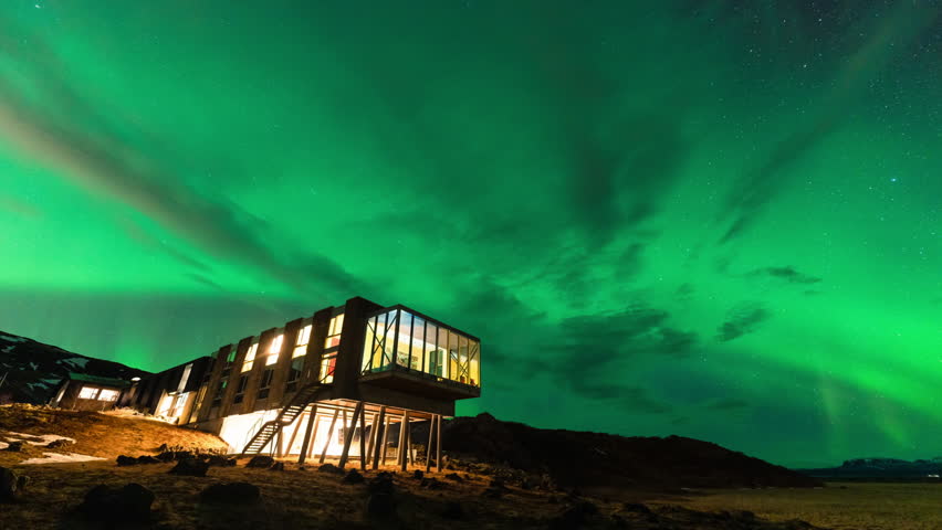 Time lapse of Beautiful scenic view of Aurora borealis, Northern lights glowing over luxury hotel on mount Hengill in winter at Nesjavellir, Iceland