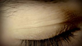 Close-up of brown eye blinking in Slow Motion. Young Woman is opening and closing her beautiful eye. 4k video footage of a closeup of a woman's eyes