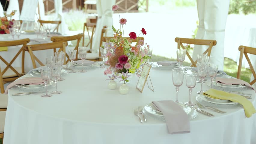 a table set for a wedding reception under a tent
