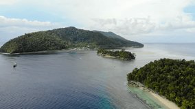 Kri island and exotic and tropical surrounding seascape, Raja Ampat in Indonesia. Aerial backward