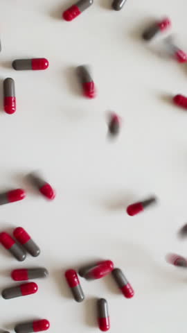 Many tablets fall to the table. A rain of pills. Vertical video.