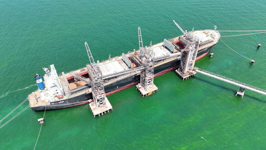 Aerial top view wood chips load chip from silo to cargo ship vessel concept green fuel for save earth. renewable energy from wood Chips	