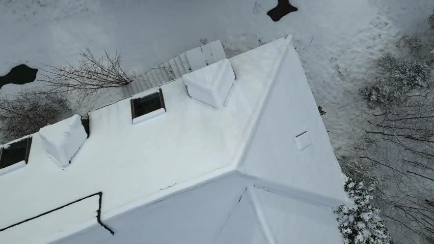 Top down birds eye view of abandoned building covered in trees snow winter landscape cold snow