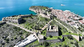 Aerial drone video of beautiful landmark castle of Palamidi built uphill overlooking iconic city of Nafplio in a nice spring morning with white clouds and deep blue sky, Argolida, Peloponnese, Greece