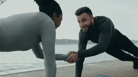 Fitness duo showcases teamwork, strength, and fun in an outdoor plank exercise, emphasizing the dynamic interaction between a Middle Eastern man and an African woman - Powered by Shutterstock - Get 15% off with code: PIKWIZARD15