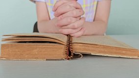 Hands of praying boy going to the first holy communion holding prayer book and wooden rosary - Powered by Shutterstock - Get 15% off with code: PIKWIZARD15