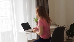 woman working at home on a computer, talking on the phone, businesswoman or student looking at laptop learning, serious girl working or studying computer doing research or preparing for exam online.