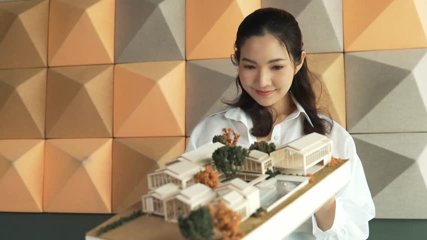 Skilled attractive architect engineer holds architect model while checking mistake point carefully. Project manager inspect architectural model by lifting left side and right side. Manipulator. - Powered by Shutterstock - Get 15% off with code: PIKWIZARD15