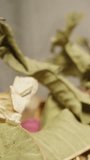 A tea ceremony, with scattered floral tea and brewing utensils on the table. Dolly slider extreme close-up. Vertical video.