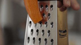 close up grating carrots, carrots are grated
