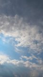 Dark grey clouds accumulating in the atmosphere. Cumulus clouds covering the sky. Timelapse. Vertical video