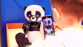 a boy films a robot panda at a robot exhibition with his phone - Powered by Shutterstock - Get 15% off with code: PIKWIZARD15