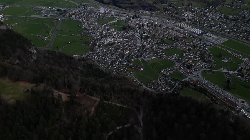 Top-view, high-altitude aerial perspective of Glarus, Switzerland, showcasing its pristine natural beauty and charming urban landscape nestled amidst the breathtaking Swiss Alps.