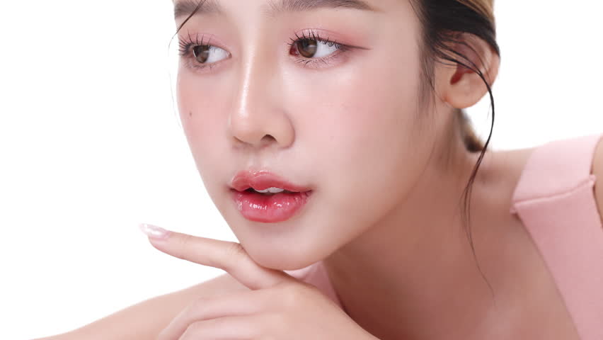 Close up portrait beautiful young Asian woman with healthy facial skin opening eyes isolated over white background.