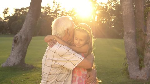 Happy grandfather and granddaughter outdoors. Grandpa holding granddaughter, summer nature background. Happiness inside us.