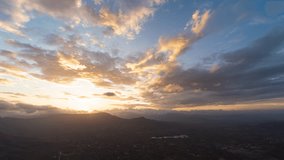 Timelapse of a Sunset. The sun is setting behind a mountain over a valley with a colour explosion occuring right before the sun sets. Shot in 4K ultra HD in 60fps for a smooth and a clear video.