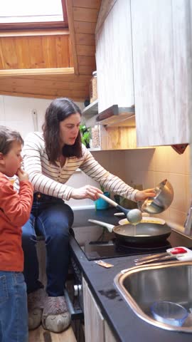 Mother and son cooking some pancakes together in the kitchen of their home Royalty-Free Stock Footage #3468217027