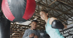 Video of fit diverse woman and man boxing at gym. active, fit, sporty and healthy lifestyle, exercising at gym concept.