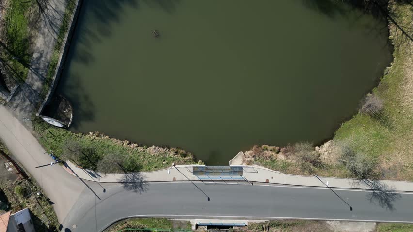 bridge tributary of the pond above the water walkway for pedestrians made of lattice transparent mesh. coastal promenade around the lake