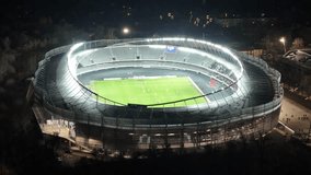 Kaunas Darius and Girenas stadium at night with lights on and football match going. Aerial view 4K footage, drone video