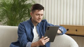 A positive man is a creative freelancer who uses the Internet and a tablet, communicates on a social network. - Powered by Shutterstock - Get 15% off with code: PIKWIZARD15