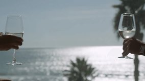 Couple clinking glass of white wine in front of sea - Powered by Shutterstock - Get 15% off with code: PIKWIZARD15